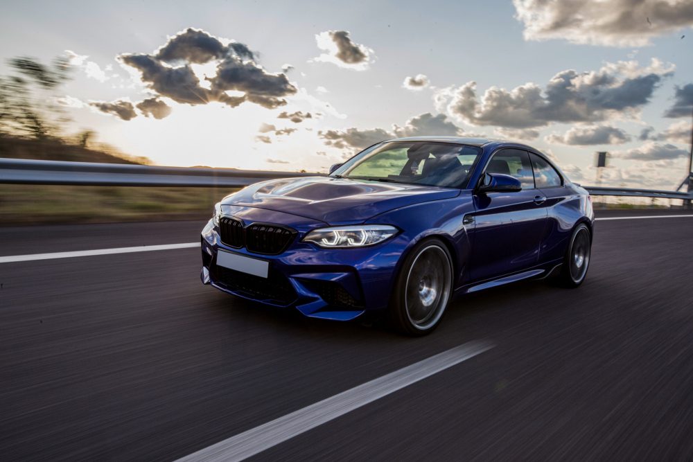 blue-sedan-car-driving-road-cloudy-weather-1